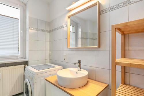a bathroom with a sink and a washing machine at Im Herzen Templins Obergeschoss in Templin