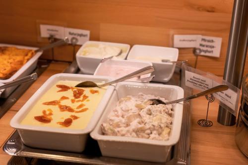 a table with several trays of food on a counter at Hotel Pension Futterknecht in Burgau