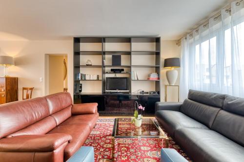 un salon avec un canapé en cuir et une télévision dans l'établissement Françoise F5 avec parking, à Rouen