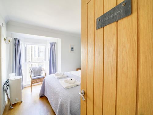 a bedroom with a bed and a wooden door at The Artist Loft, Ensuite Guest Rooms, Porthleven in Porthleven