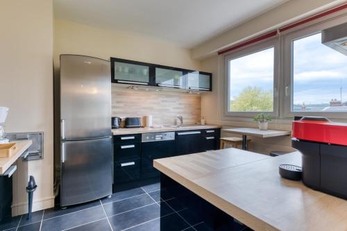 Il comprend une cuisine équipée d'un grand réfrigérateur en acier inoxydable. dans l'établissement Françoise F5 avec parking, à Rouen