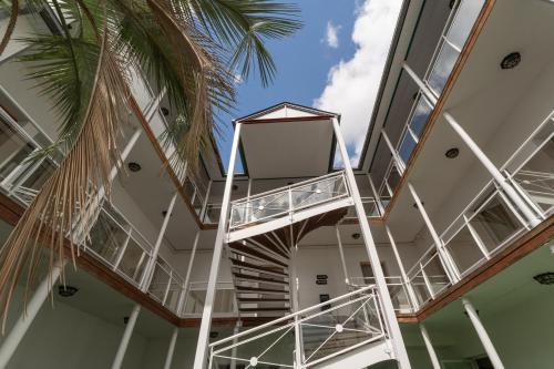 a spiral staircase in a building with a palm tree at Brit Hotel Ker Lann Aeroport - Parc Expo in Bruz