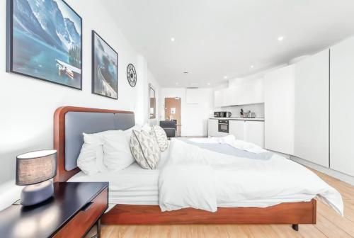 une chambre blanche avec un grand lit et un bureau dans l'établissement Stylish Studio in Piccadilly Central London VR2, à Londres
