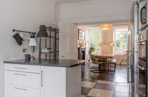 Una cocina con gabinetes blancos y una encimera negra. en GuestReady - Charming house in Dublin, en Dublín