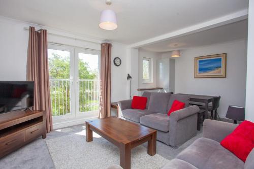 a living room with a couch and a tv at 3 Bedroom Duplex with Free Parking in Glasgow