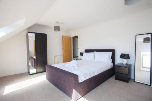 a bedroom with a large bed and a mirror at 3 Bedroom Duplex with Free Parking in Glasgow