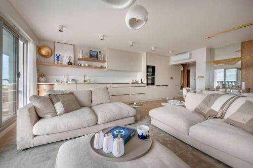 un salon avec deux canapés et une cuisine dans l'établissement Appartement de standing en front de mer, pour 4, à La Baule