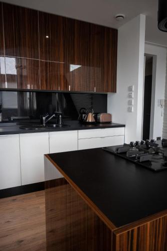 a kitchen with a black counter top and wooden cabinets at Stunning 3 Bed Penthouse in West End in Glasgow