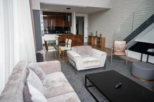 a living room with a couch and chairs and a piano at Stunning 3 Bed Penthouse in West End in Glasgow