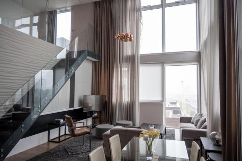a living room with a glass table and a staircase at Stunning 3 Bed Penthouse in West End in Glasgow