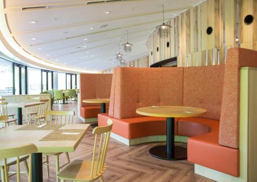 a restaurant with tables and chairs in a room at Holiday Inn Resort Shinano-Omachi Kuroyon by IHG in Omachi