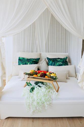a white bed with flowers on top of it at WellTime PrivateSpa in Heiligenhaus