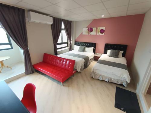 a hotel room with two beds and a red couch at Light Shadow in Budai