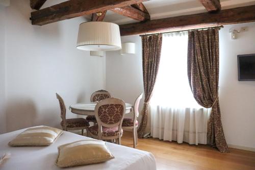 a bedroom with a bed and a table and chairs at Al Redentore Di Venezia in Venice