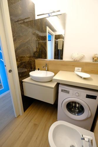 a bathroom with a sink and a washing machine at Perla Blu by PortofinoVacanze in Rapallo