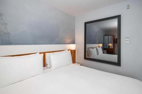 a bedroom with a large bed and a mirror at DoubleTree by Hilton Hotel London - Tower of London in London