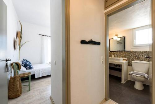 een badkamer met een toilet, een wastafel en een bed bij Villa Hara Naousa in Naousa