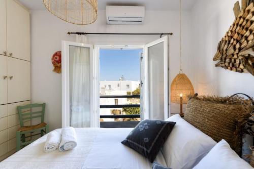 een slaapkamer met een bed en een groot raam bij Villa Hara Naousa in Naousa