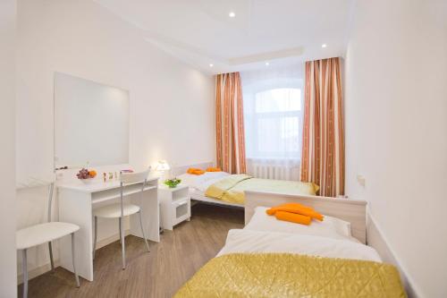 1 dormitorio con 2 camas, escritorio y espejo en Guest House on Kazanskaya, en San Petersburgo