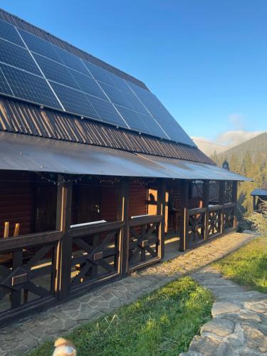 a barn with solar panels on the roof at Khatky Na Penkakh in Vorokhta