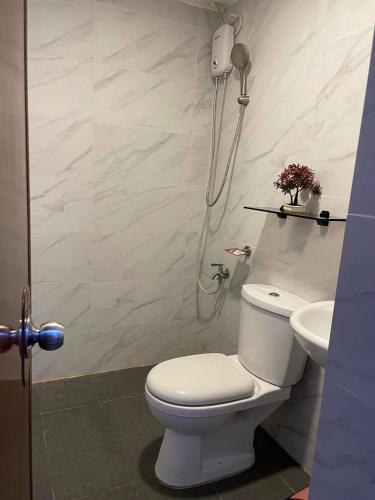 a bathroom with a toilet and a sink at Kwartos Inn Building 101, 10th Floor ,Unit 1030 in Lo-oc