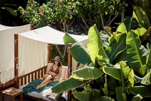 a woman in a bikini sitting on a bed at Nissi Park Hotel in Ayia Napa