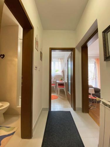 a hallway with a bathroom with a toilet and a table at Apartments Xenia Krk in Krk