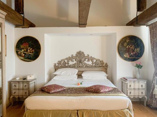a bedroom with a bed with two tables and two pictures on the wall at Al Redentore Di Venezia in Venice