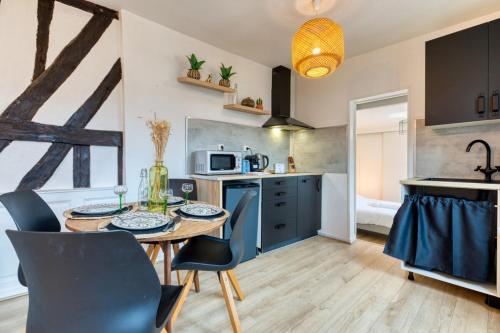 une cuisine avec une table et des chaises dans une cuisine dans l'établissement Romain Charmant F2 sur cour calme en centre ville, à Rouen