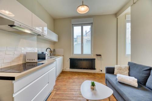 une cuisine et un salon avec un canapé et une table dans l'établissement L'Oiseau Blanc un petit nid proche de la gare !, à Rouen