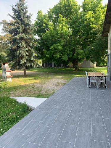 a patio with a table and chairs and trees at Maison d'Emmannaelle in Auros