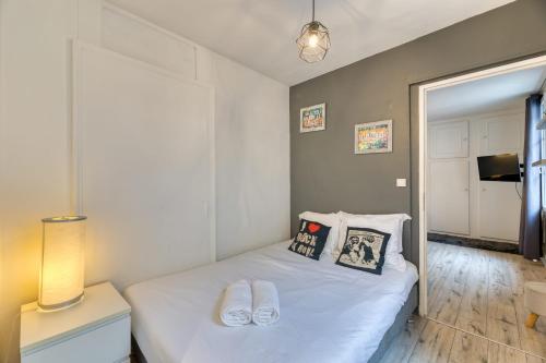 une chambre avec un lit avec des draps blancs et des oreillers dans l'établissement Le Music votre joli F2 au cœur de Rouen !, à Rouen