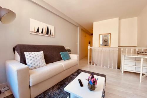 un salon avec un canapé et une table dans l'établissement Bright duplex 50m from the port of La Rochelle, à La Rochelle