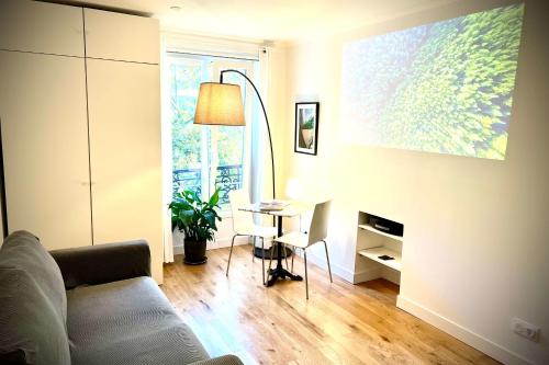 un salon avec un canapé et une table dans l'établissement Charming 2 rooms near Gare de Lyon, à Paris