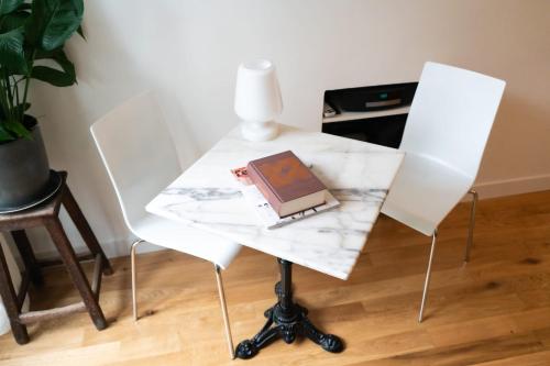 - une table blanche avec un ordinateur portable dans l'établissement Charming 2 rooms near Gare de Lyon, à Paris