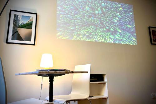 une table et des chaises dans une pièce ornée d'un tableau mural dans l'établissement Charming 2 rooms near Gare de Lyon, à Paris