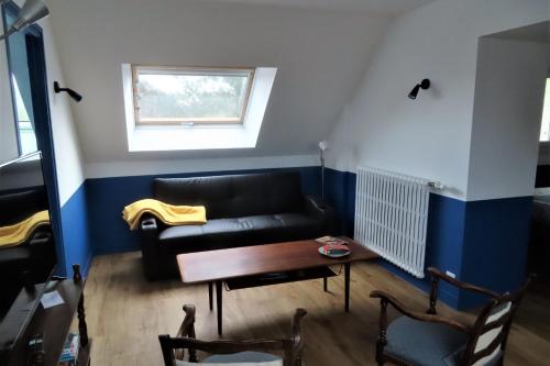 un salon avec un canapé noir et une table dans l'établissement Nice T4 of 65 m2 with garden in Ouistreham, à Ouistreham