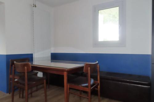 une table à manger avec deux chaises et une fenêtre dans l'établissement Nice T4 of 65 m2 with garden in Ouistreham, à Ouistreham