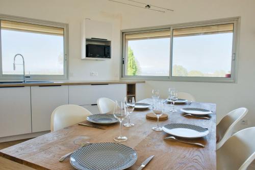 une cuisine et une salle à manger avec une table et des chaises en bois dans l'établissement Comfortable and spacious house with terraces, à Saint-Nazaire