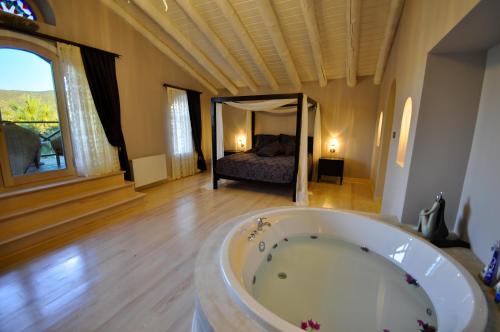 a bath tub in a room with a bedroom at Oliviera Private Island Hotel - Kalem Island in Kalem Adasi