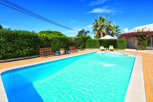 a swimming pool with blue water in a yard at Casa Santalena in Carvoeiro