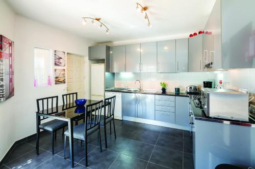 a kitchen with blue cabinets and a table and chairs at Casa Santalena in Carvoeiro