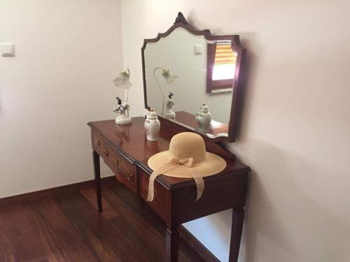 a hat sitting on a dresser in front of a mirror at O Douro aqui tão perto in Santo Adrião
