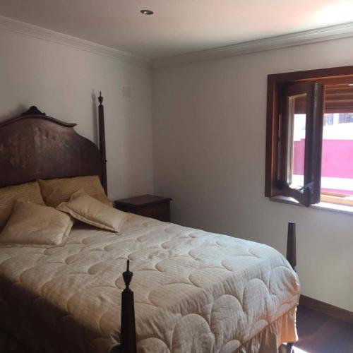 a bedroom with a large bed with a window at O Douro aqui tão perto in Santo Adrião