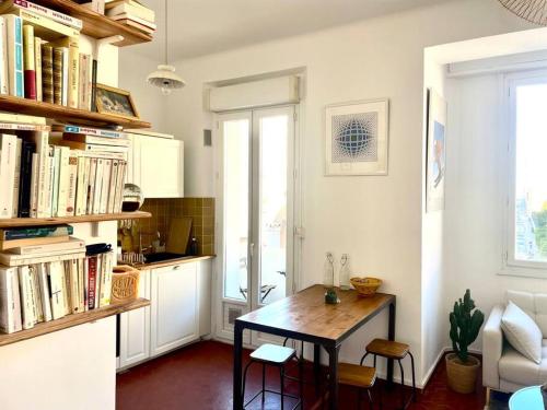 une cuisine avec une table et des chaises dans une pièce dans l'établissement Appartement entre Endoume et Samatan, à Marseille