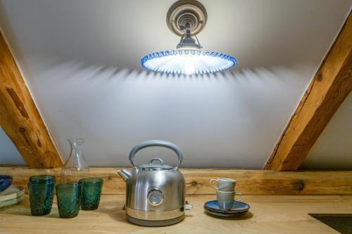 a tea kettle sitting on a wooden table with glasses at Kaszelewskiego1 in Zakopane