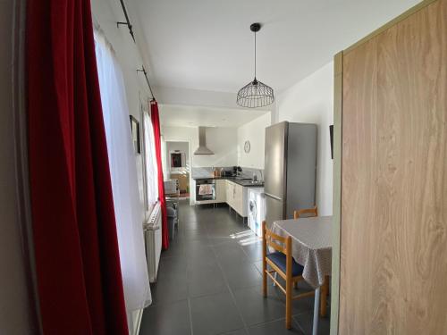 Il comprend une cuisine et une salle à manger avec une table et un réfrigérateur. dans l'établissement Le repos des Thermes, à Rochefort