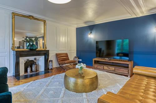 un salon avec un canapé, une table et une télévision dans l'établissement L'Ambassadeur appartement époustouflant en plein coeur de Rouen, à Rouen
