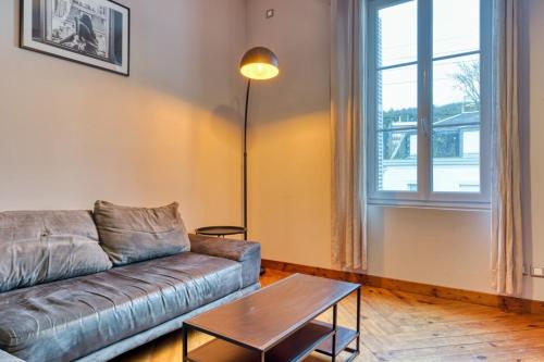 un salon avec un canapé et une table dans l'établissement Julie beau F6 rénové terrasse parking Rouen, à Grand-Couronne