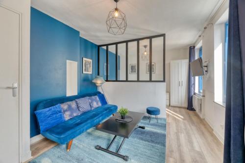 un salon avec un canapé bleu et une table dans l'établissement Le BlueArt votre logement au cœur de Rouen, à Rouen